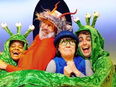 Red smed and blue smoo performers cuddled by green aliens
