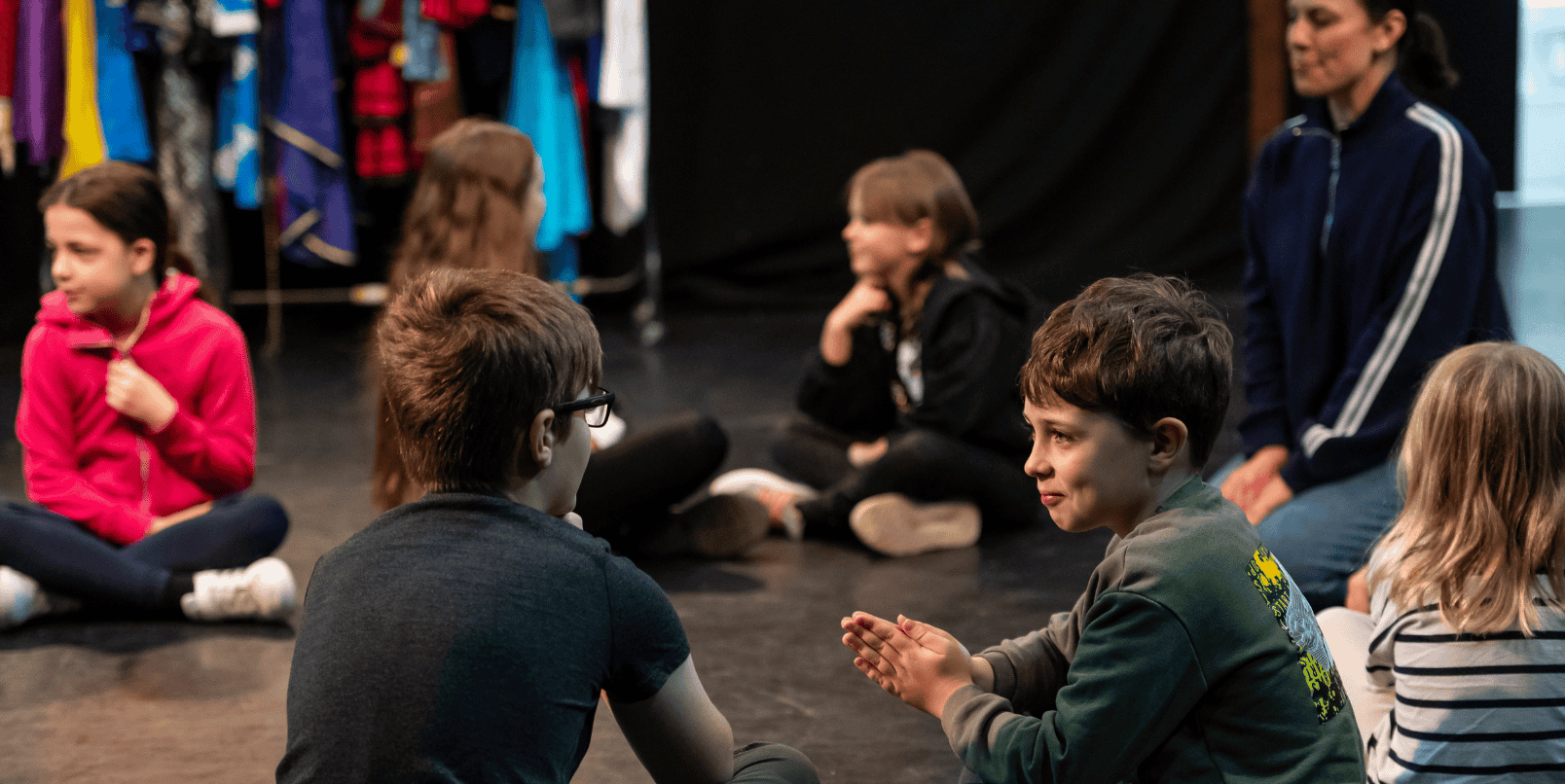 Children taking part in a workshop sitting in a circle 