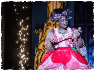 A panto fairy in a pink dress holding a wand
