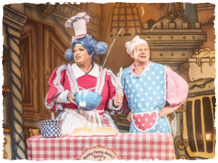 Peter Gordon and Matt Pinches as Nanny Fannie Annie and Much in front of a table with a picnic cover flinging slosh at each other's faces