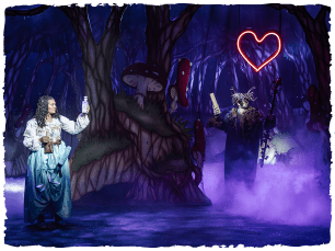Safia Bartley as Marion stands in a dark forest with a floating red heart in the air