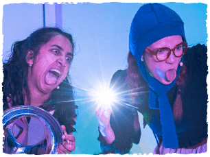 2 actors pulling funny faces and holding torches