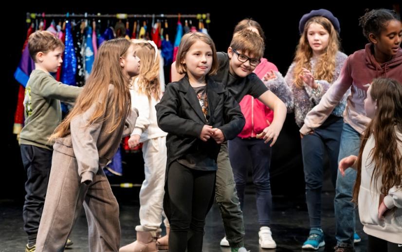 A group of children stand in a workshop