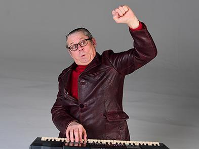 Johnathan Shuttleworth raising his hand and playing on a keyboard
