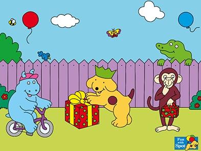 Spot a golden cartoon dog with a brown spot is in the centre opening a present wearing a green party crown hat. On the left a blue hippo is riding a purple bike. On the right a monkey holding a bag. They are in a garden with a purple fence along the back of the image. A green alligator is looking over the fence.