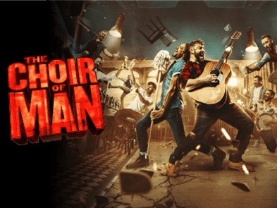 Red text reading choir of man. Two men back to back, singing playing guitar