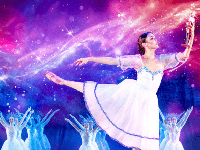 Ballerina, holding a nutcracker, with her leg extended behind her.