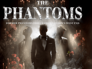 Promotional poster for "The Phantoms," featuring silhouettes of three men in tuxedos surrounded by smoke, red roses, and candlelight. Text reads "The Phantoms – Former Phantoms Direct from London’s West End." On the right, a circular spotlighted portrait of Lee Mead appears, with the text: "Starring West End & TV Star Lee Mead. A Spellbinding Evening Celebrating the Most Beloved Musicals of All Time."