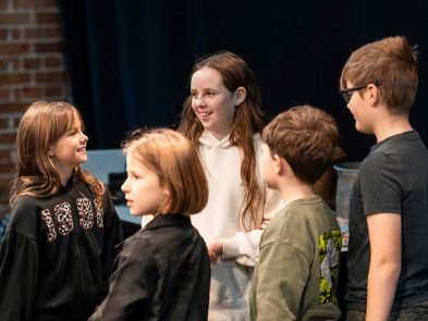 5 children in a group, acting out a scene
